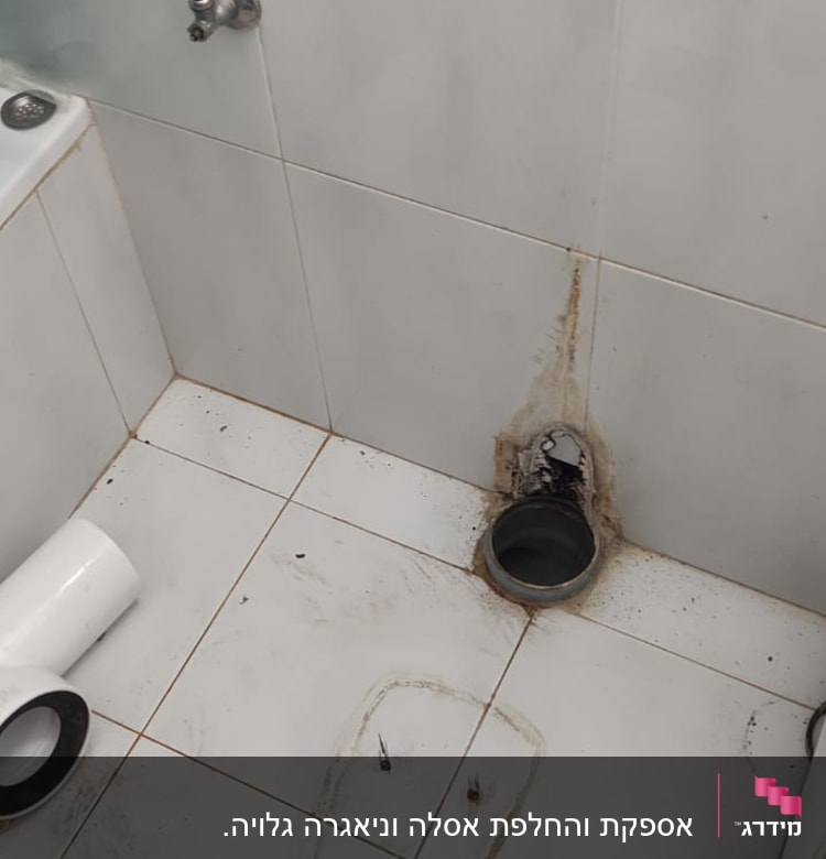 חלקי צנרת וכלים על רצפת חדר אמבטיה